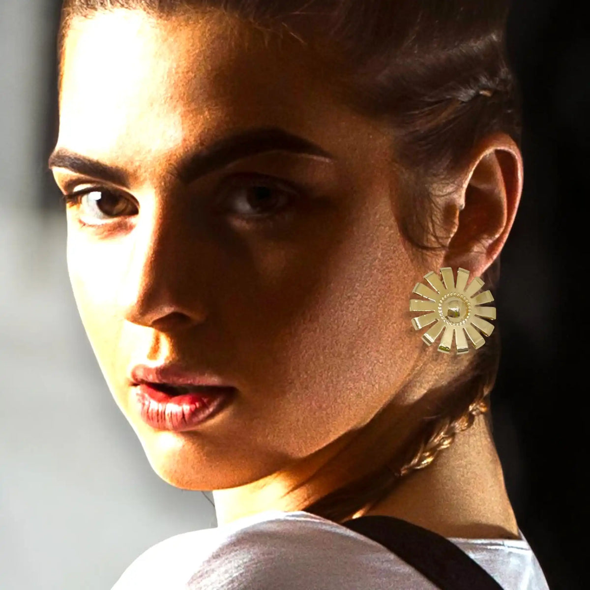 Gold sunburst earring.