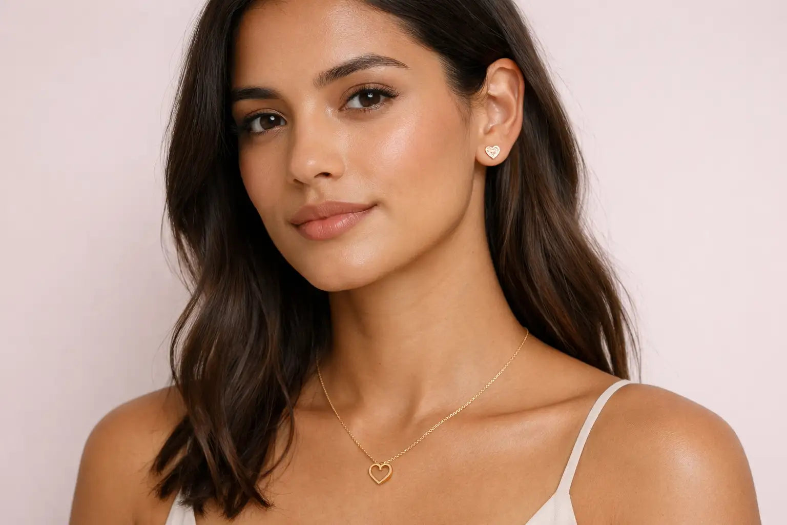 Gold heart-shaped pendant necklace with delicate chain and matching gold heart stud earrings