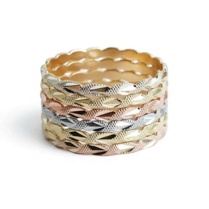 Gold and silver textured stacking rings with a scalloped edge.